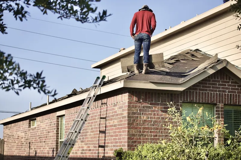 Professional roofer working on a residential roof in Voluntown